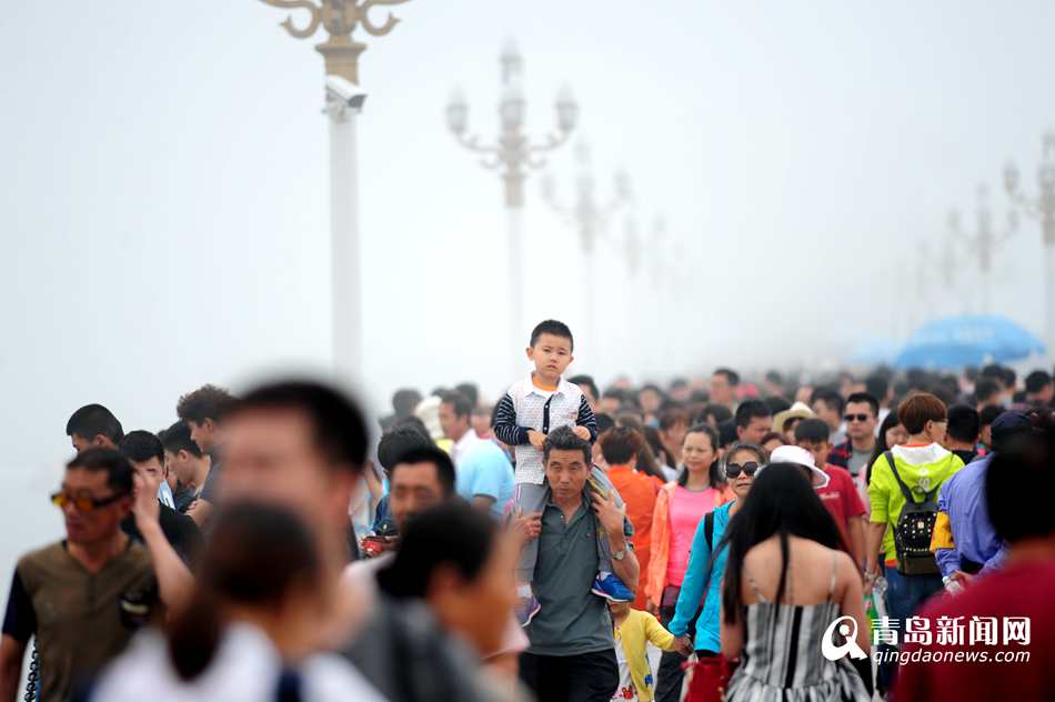 高清:青岛前海一线游人如织 栈桥变身人桥