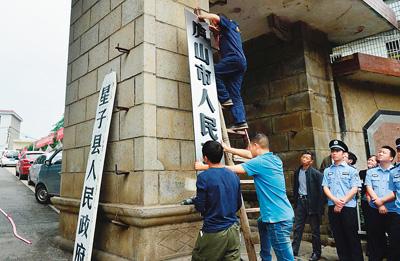 5月30日，江西省庐山市正式成立。图为工作人员悬挂庐山市人民政府的牌子。一旁是刚刚取下的星子县人民政府的牌子。