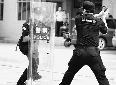 胡光志（左）向华容县公安局特警演示用盾牌防御