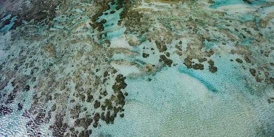 南沙群岛是我国分布面积最广、岛礁数量最多的群岛，也是个迷人的世界。天是一片蓝玉，海是一块翡翠。远望水天相连，仿佛翡翠和蓝玉合璧，蔚为壮观。记者通过航拍，展示了中国这片美丽海域的肌肤和纹理。解放军报记者孙阳摄