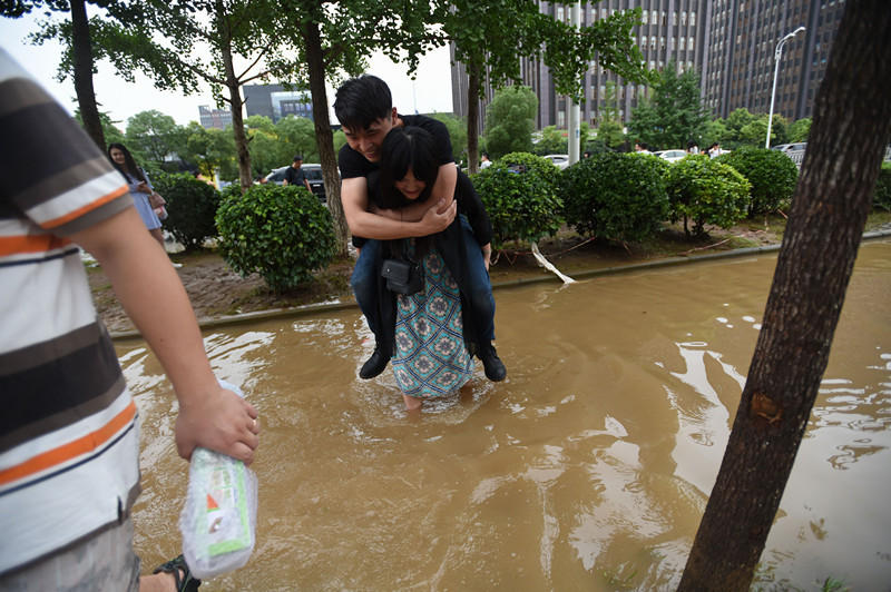 武汉市区积水：“女汉子”肩扛男友过马路