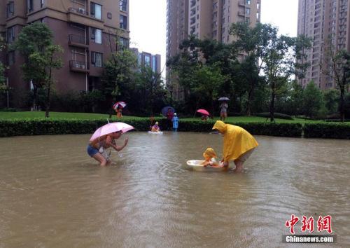 资料图：7月6日，武汉一小区成了儿童戏水场。中新社记者 刘莉莉 摄