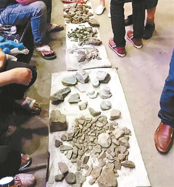 人们在施工工地一侧摆摊卖玉