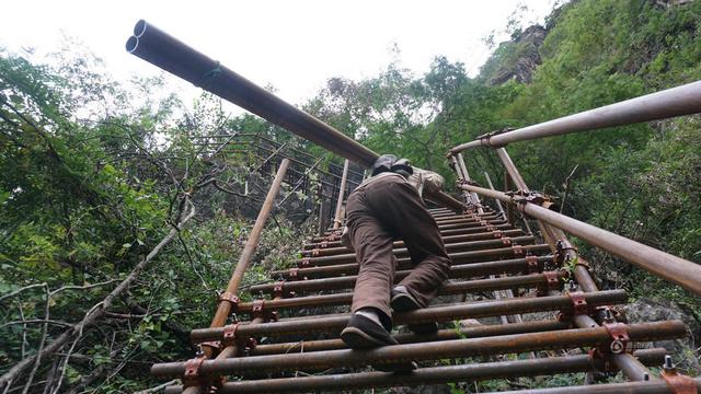 组图：绝壁修路 村民背1500根钢管上山造天梯