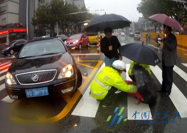 女子雨中被撞倒地 民警为其撑伞遮雨