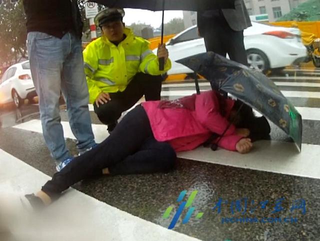 女子雨中被撞倒地 民警为其撑伞遮雨