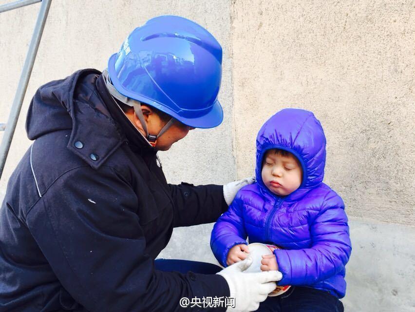 男孩雪地捧方便面睡着 父亲在旁修电路