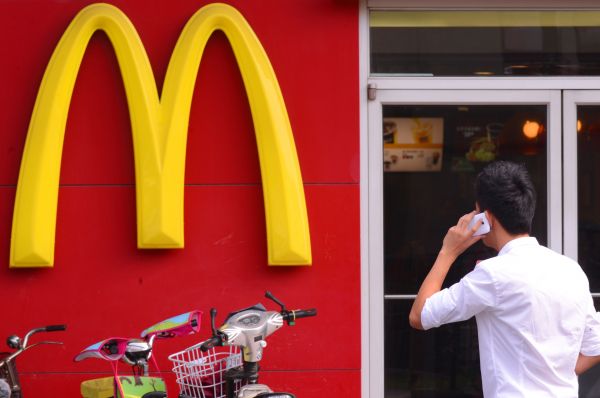 资料图片：一名男子在位于北京站附近的麦当劳门店外打电话。新华社记者 李贺 摄