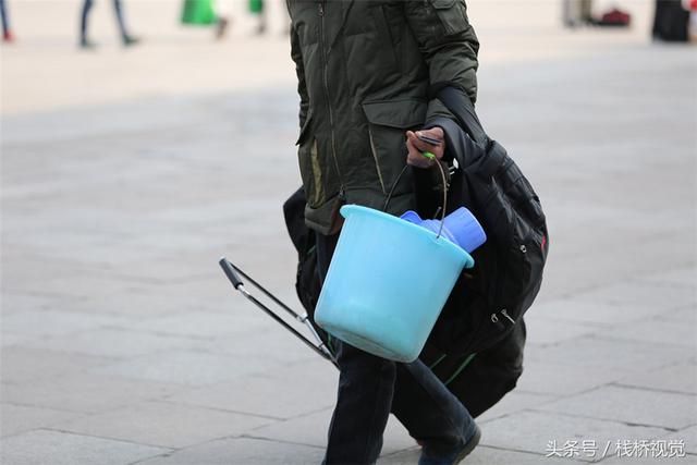 青岛火车站迎农民工返乡大军 编织袋、塑料桶成标配