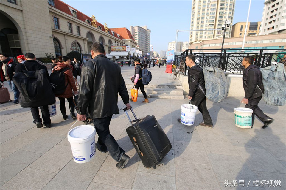 青岛火车站迎农民工返乡大军 编织袋、塑料桶成标配