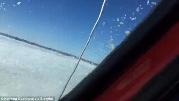 情侣在冰冻湖面上开车