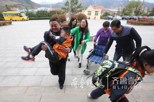 青岛这个男娃骨折两个月 老师们轮流抱他上课
