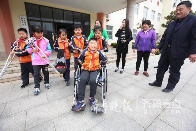 青岛这个男娃骨折两个月 老师们轮流抱他上课