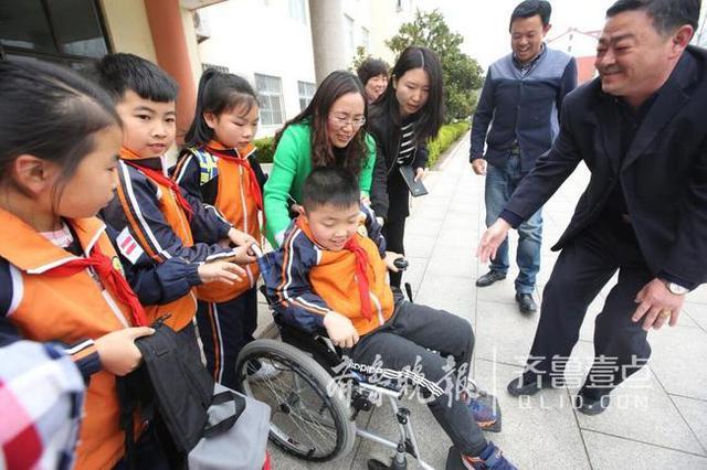 青岛这个男娃骨折两个月 老师们轮流抱他上课