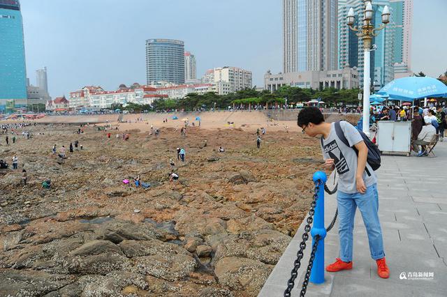 高清:栈桥跌大潮露出壮观礁石阵 游客热闹赶海