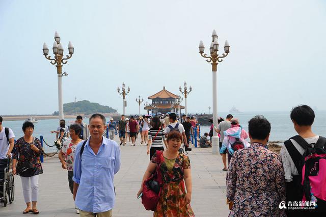 高清:栈桥跌大潮露出壮观礁石阵 游客热闹赶海