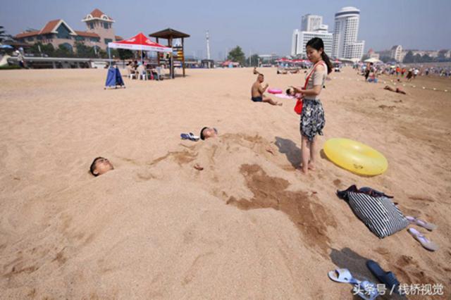 青岛独特日光浴？海滩上将身体埋进沙子里