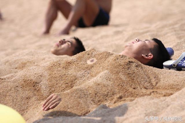青岛独特日光浴？海滩上将身体埋进沙子里