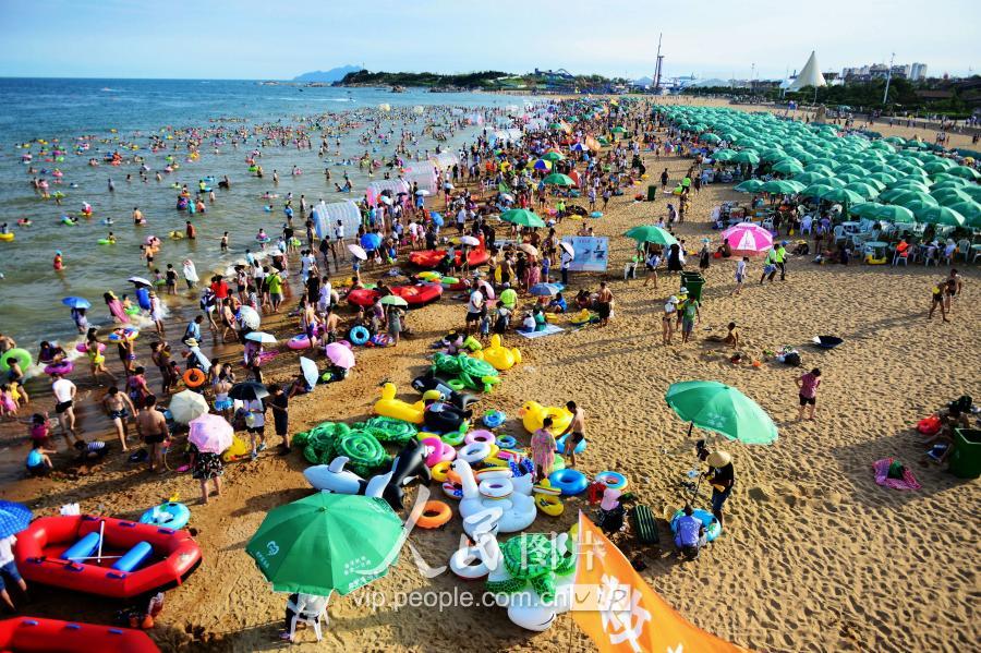 夏日青岛人气爆棚 游客洗海澡享清凉