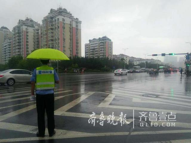 青岛辅警雨中执勤 美女路人帮助撑伞雨停才走 青岛辅警雨中执勤 美女路人帮助撑伞雨停才走